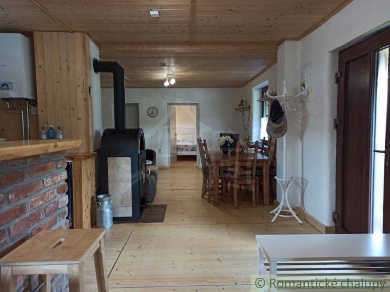 A wooden interior with a fireplace, dining table, and rustic elements creates a cozy atmosphere in the cabin.