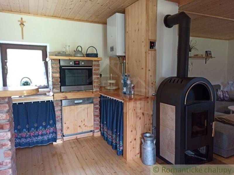 A traditional cottage with a wooden kitchen, warmth from the stove, and original decorations.