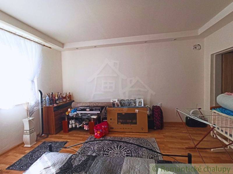 Room in a family house with light walls and furniture, bottles on the shelf.