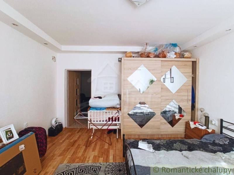 Bedroom with wooden flooring, wardrobe, and drying rack, suitable for a family house.