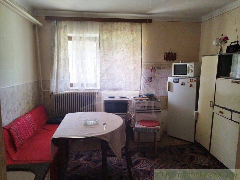 A kitchen in a family house with retro furniture, a stove, and a refrigerator.
