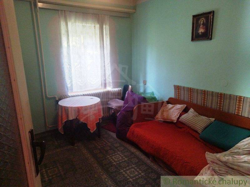 A room with a bed, a picture, and a blanket, a family house, cozy interior.