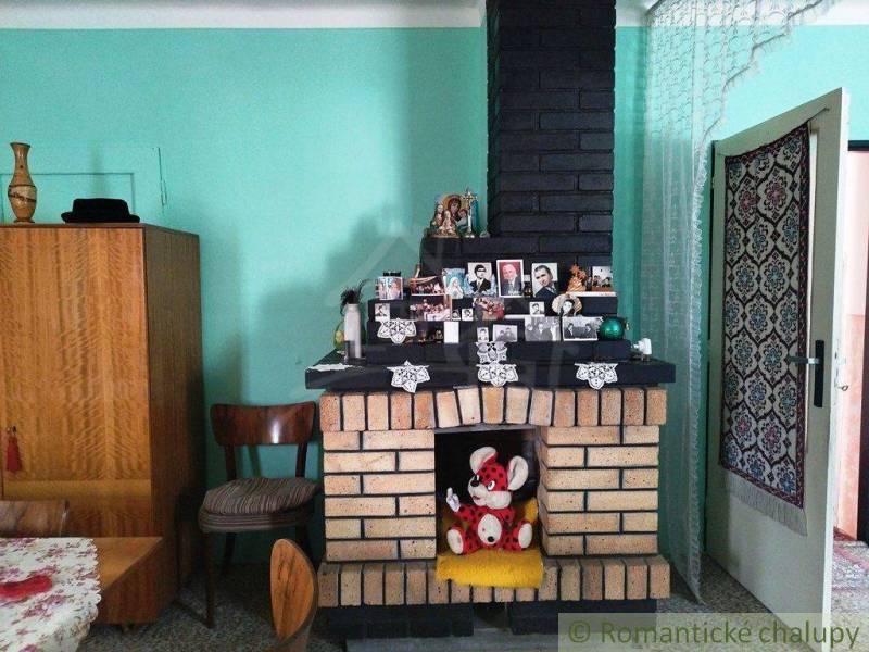 A brick fireplace in a family house surrounded by photos, furniture, and Easter decorations.