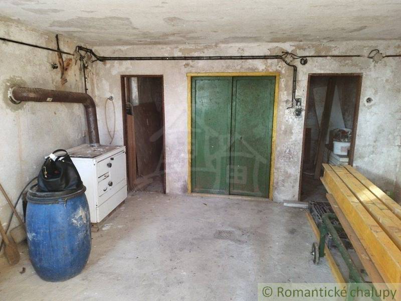 In the picture, there is a workshop with wooden elements and a blue barrel near the cabin.