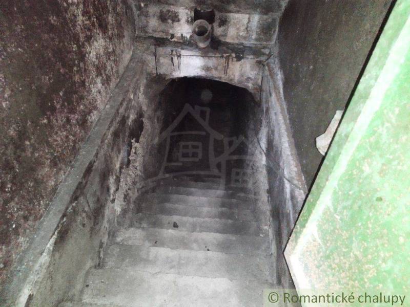 Stone staircase leading to a dark basement, ideal for a cottage or cabin.