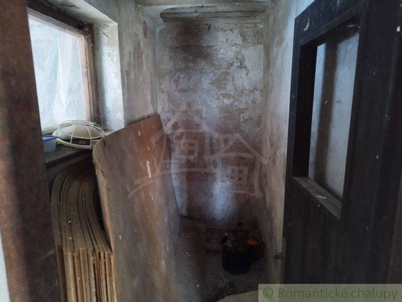 A narrow room with wood and an old wall, suitable for renovating a cottage.