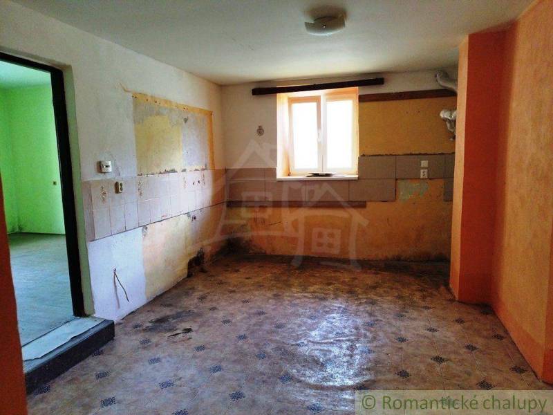 An abandoned room in a cabin with colorful walls without furniture, waiting for renovation.