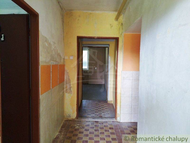 Cottage with an older interior, transitional room, colorful walls, tiles, visible wear.