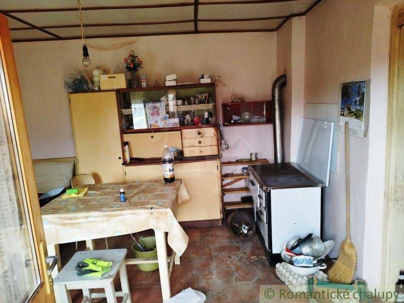 A kitchen in a family house with a classic stove, kitchen cabinets, and a dining table.