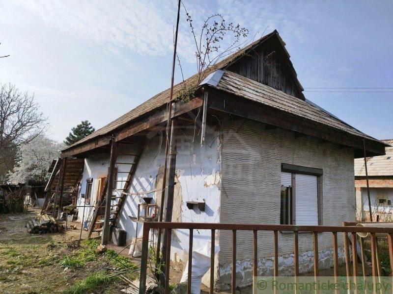 Traditional family house with a wooden roof, garden, fencing, and a rural atmosphere.
