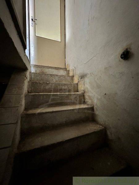 Old concrete stairs leading to the door inside a family house.