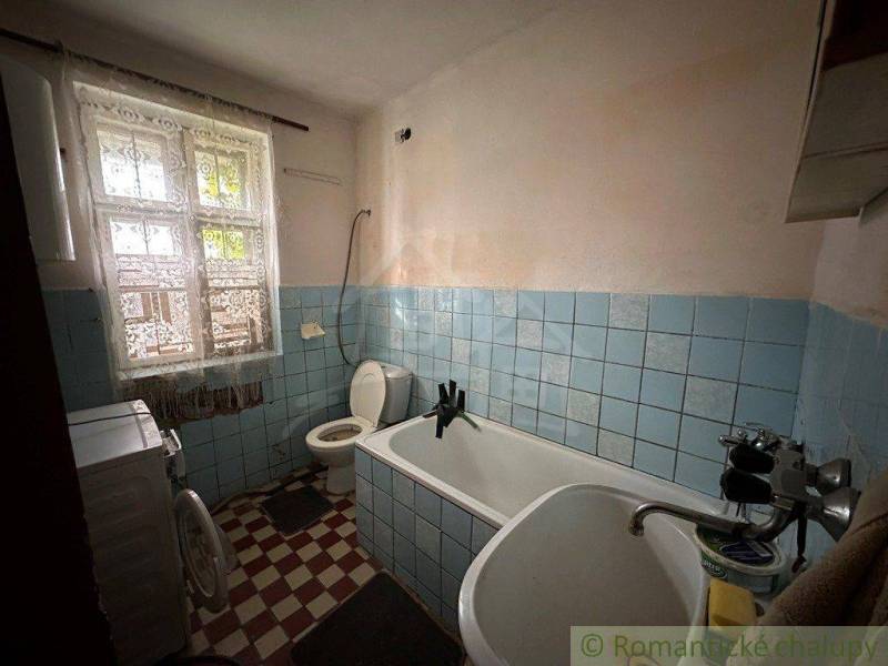 The bathroom with a bathtub, sink, and toilet in the family house is adorned with blue tiles.