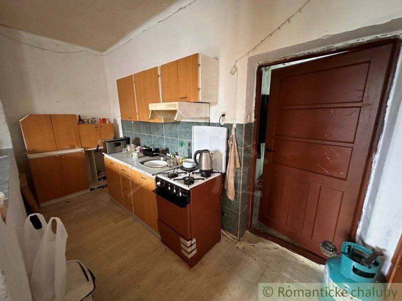 A country kitchen with wooden furniture and appliances in a family house.