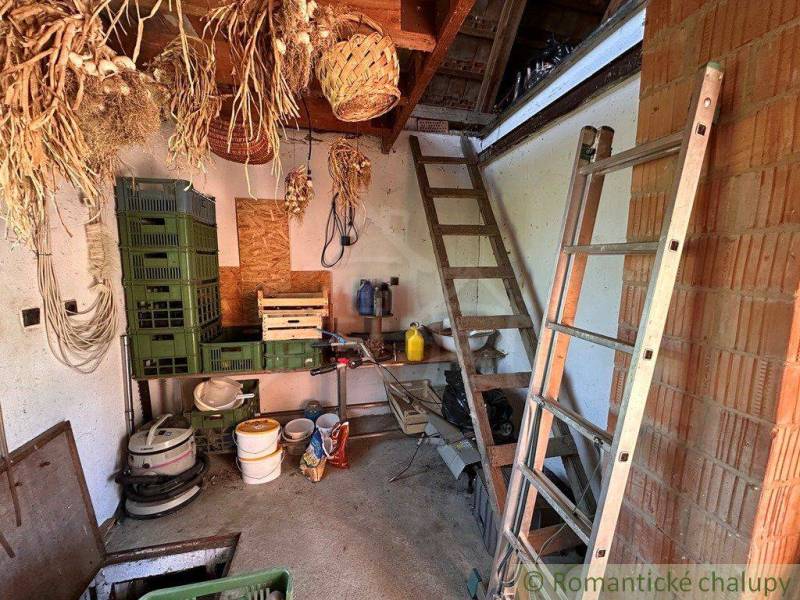 A cottage with ladders, dried onions, and storage boxes in the warehouse.