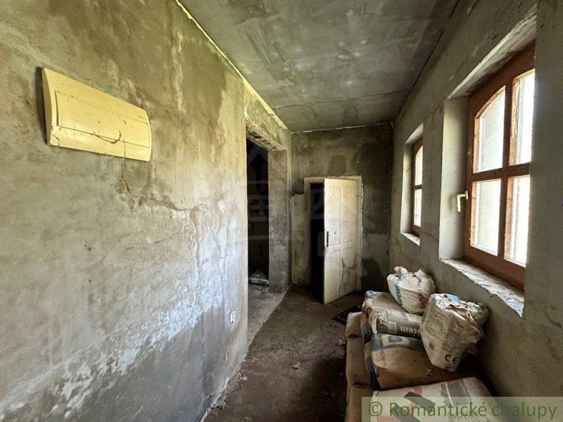 Interior with plastered walls, plastic windows, cement bags, and doors. Cottage renovation.