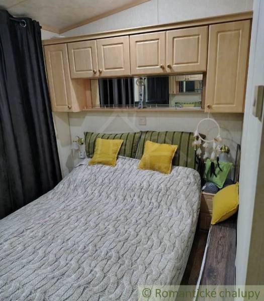 Bedroom in a family house, cozy interior with wooden cabinets and decorative pillows.