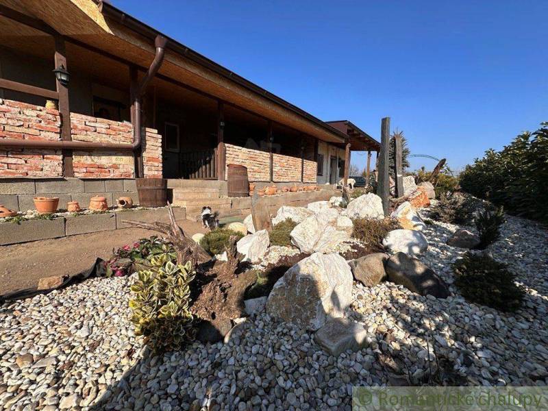 A family house with a stone garden, decorative pots, and traditional architectural elements.