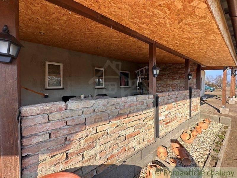 A veranda with stone walls and decorative clay pots in a family house.
