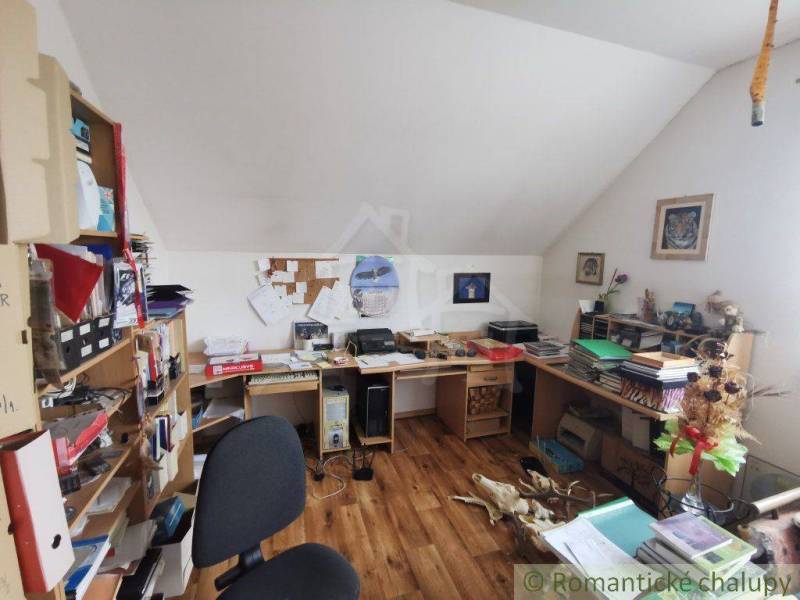 Home office with an attic, a desk, and floral decorations in a family house.