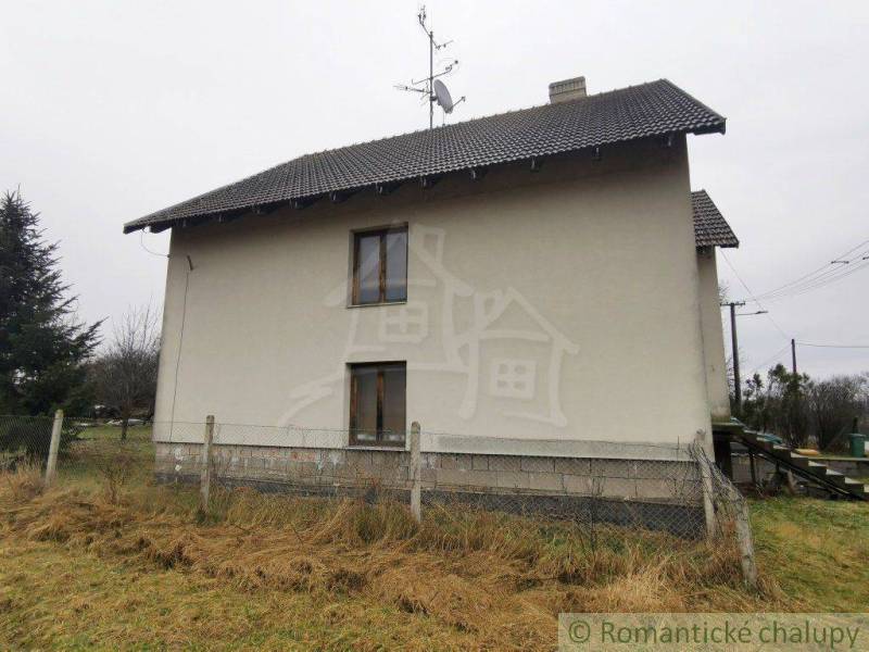The image shows a family house with a sloped roof, fencing, and a visible satellite dish.