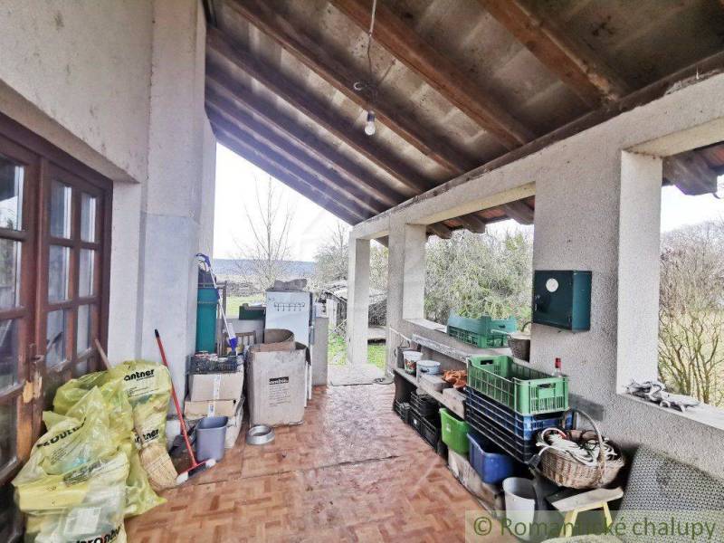 A veranda of a family house with storage space and a view of the garden.