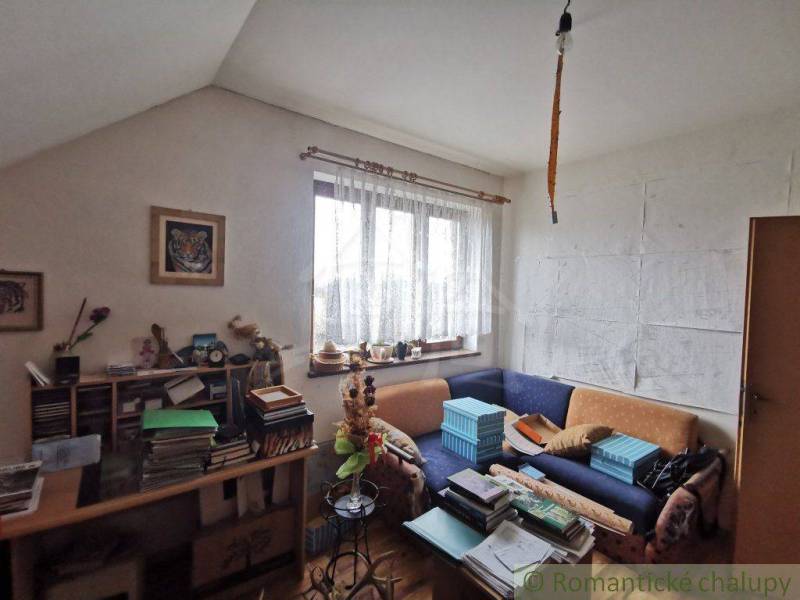 A room in a family house with a sofa, books, drawings, and decorations, creating a cozy atmosphere.