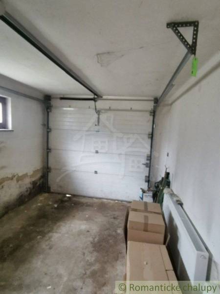 A garage with boxes and a radiator in a family house needs maintenance.