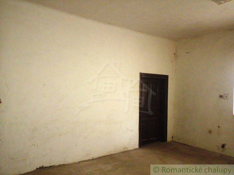 Empty room, white walls, dark door in a family house, suitable for renovation.