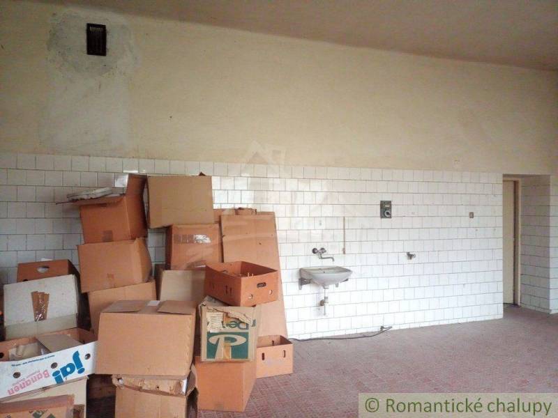 Room with a sink and many cardboard boxes in the corner of a family house.