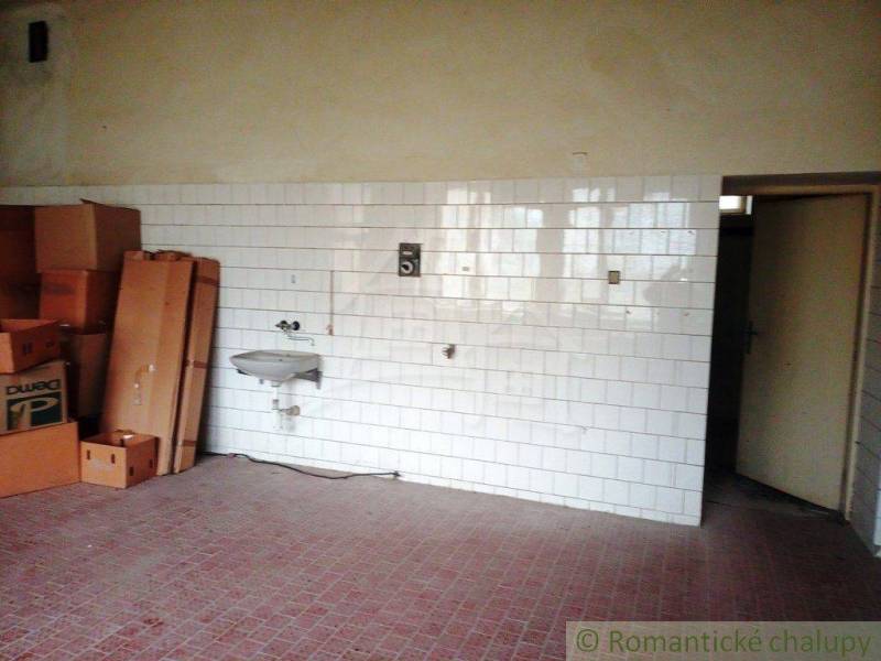 Interior with a tiled wall, a sink, and cardboard boxes, suitable for a family house.