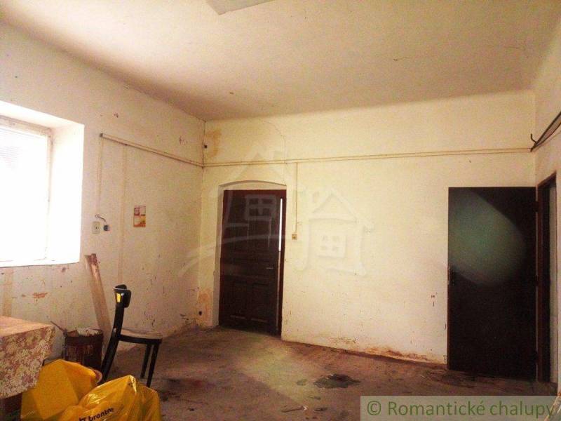 Room with worn-out walls, back door leading out of the family house.