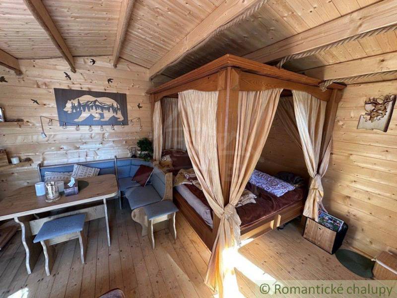A wooden room with a hand-carved bed, table, and decorations, ideal for a family home.