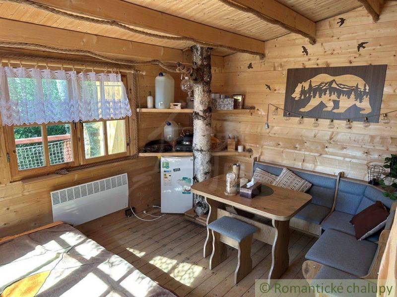 Interior of a wooden cabin, table next to the sofa, decorations in a rustic style, family home.