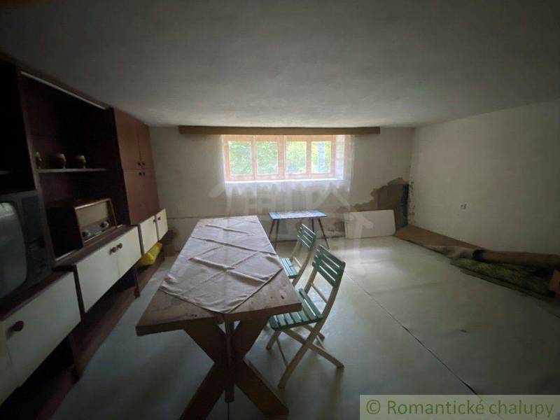Dining room in a family house with simple furniture and wooden paneling.