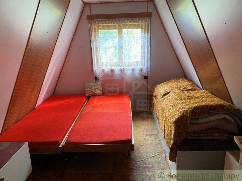 The image shows the interior of a triangular family house with beds and a window.