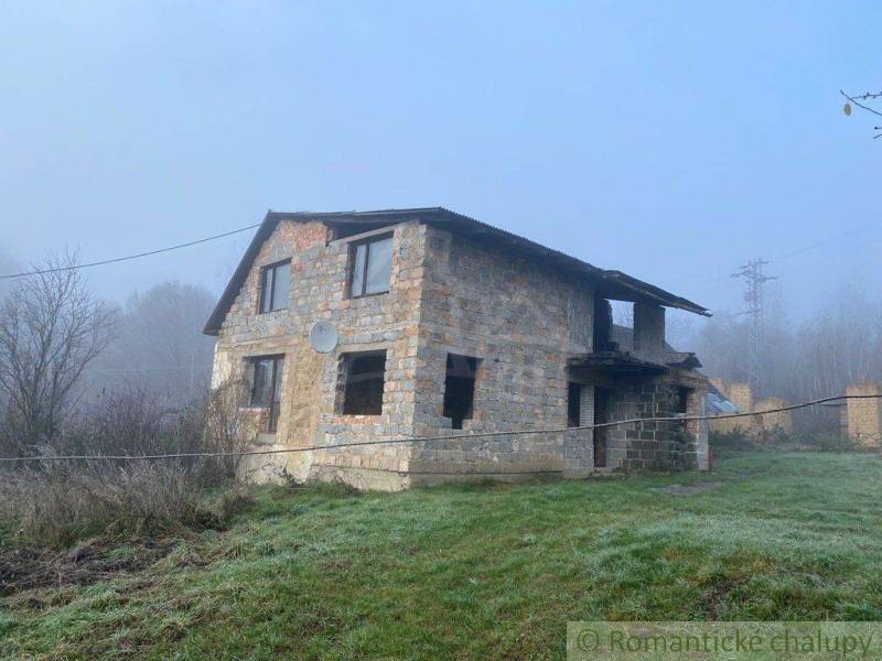 A family house in nature, an incomplete building, surrounded by a misty environment and grass.