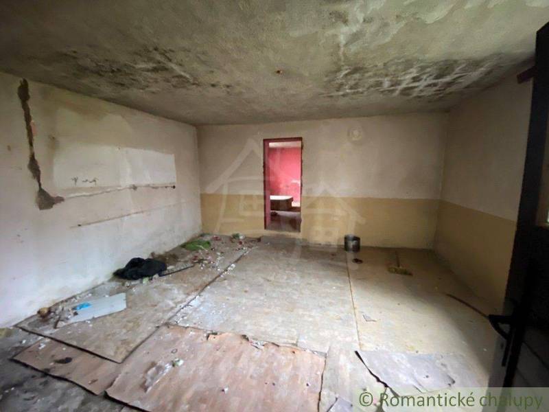 An abandoned room with damaged walls and floor in an old family house.