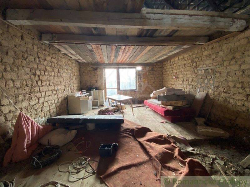An abandoned room with old furniture and earthy walls in a family house.