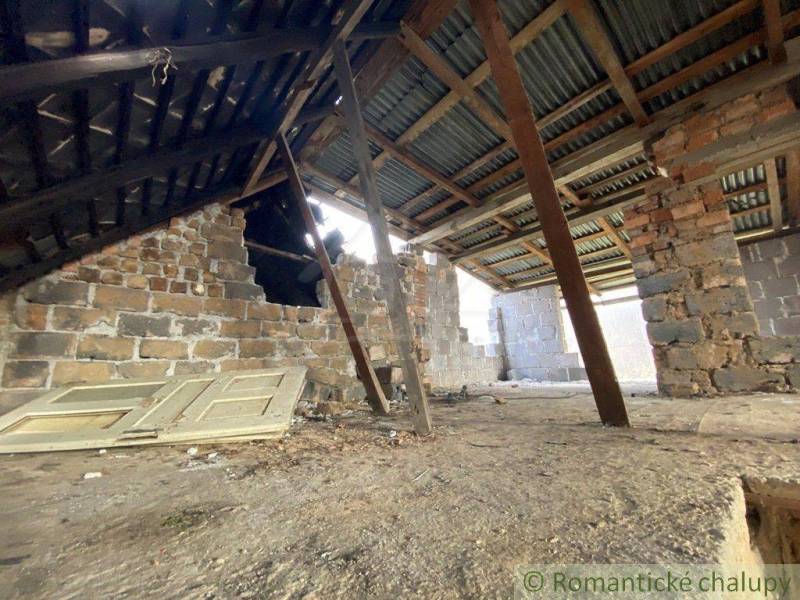 The attic in the old family house with unfinished brick walls and stored doors.