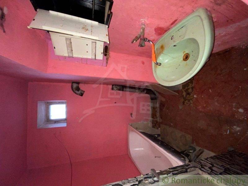 Pink bathroom and family house with a sink and a bathtub need renovation.