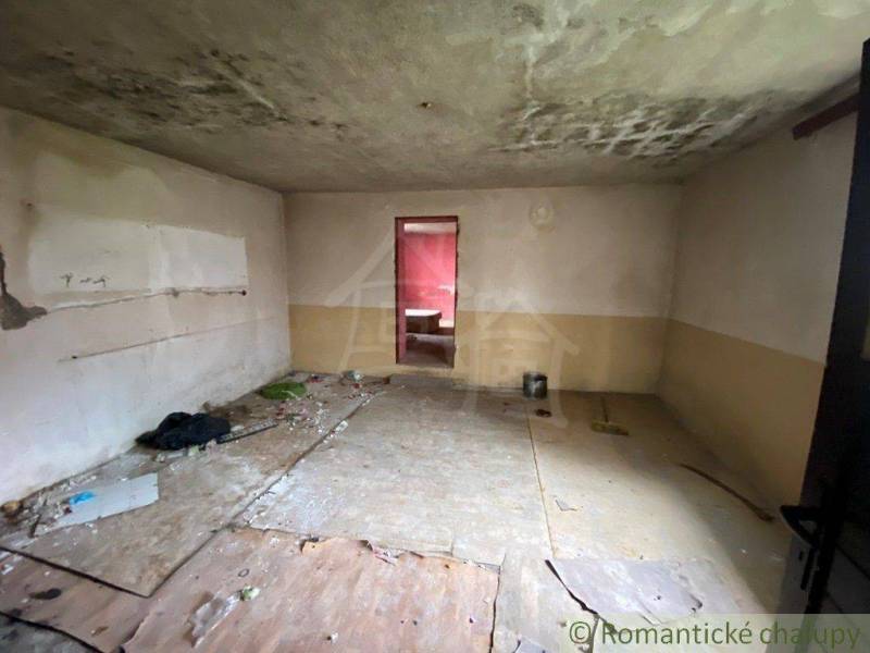 An abandoned room in a family house with a damaged floor and ceiling needs renovation.