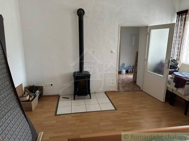 Living room with a tiled fireplace, doors, and boxes in the house.