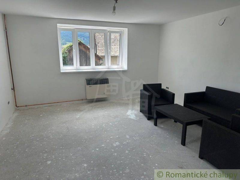 A room in a family house, black armchairs are seated, a large window with a view.