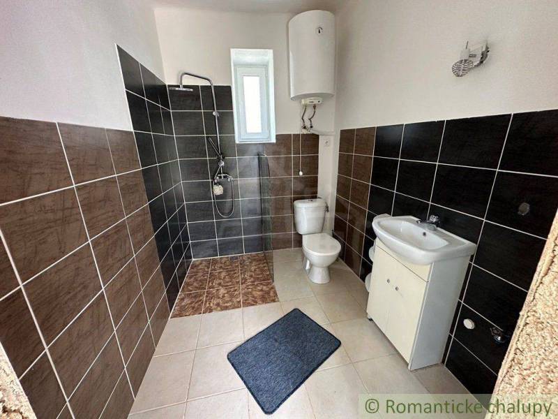 Bathroom with tiles, shower, sink, and toilet, located in a family house.