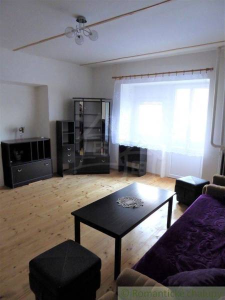 Living room with wooden flooring and furniture in a family house, cozy atmosphere.