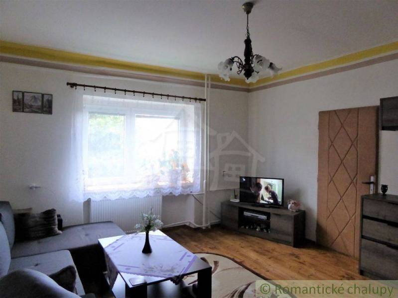 Living room of a family house with a couch, television, and curtains, ideal for relaxation.