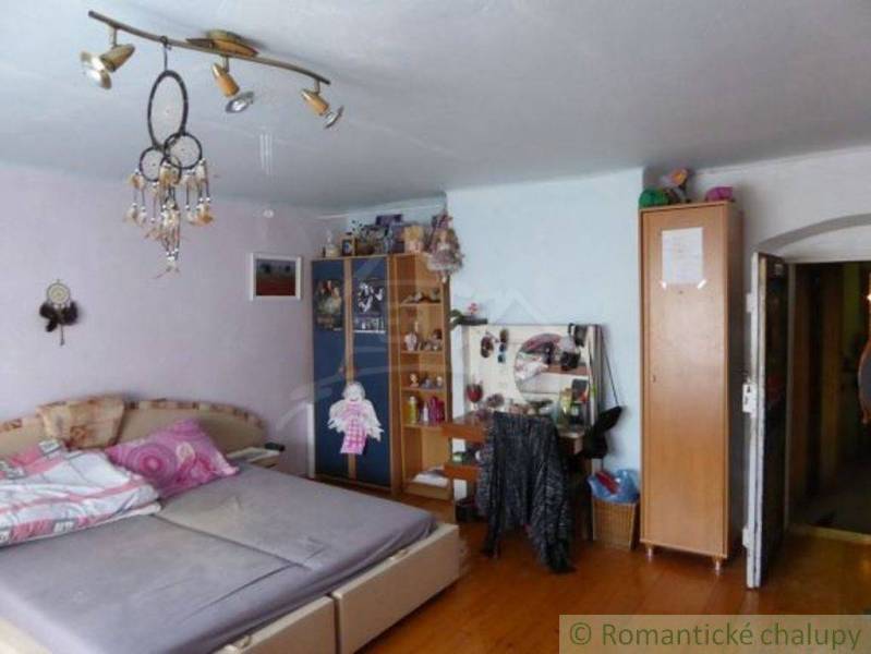 Bedroom in a family house with a bed, cabinets, and lamps.