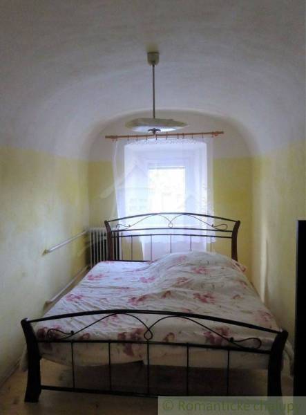 Bedroom with a metal bed and arched ceiling for a family house, cozily styled.