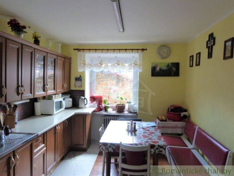 Traditional kitchen with wooden cabinets and a large dining table in a family house.
