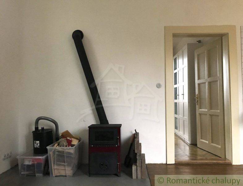 In a room with a wood-gas fireplace, you can see doors and stored items.